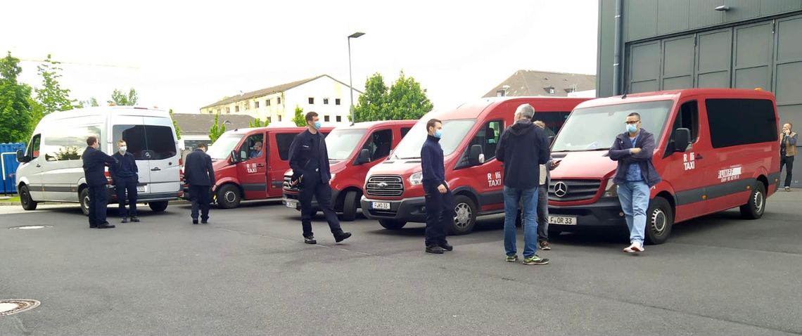 Fahrzeugflotte mit Fahrern warten auf Einsatz zum evakuieren.